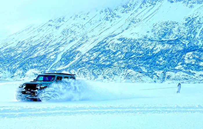 Skiing Behind Jeep on Glacial Lake